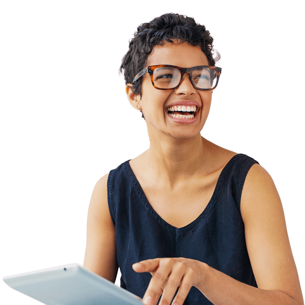 Woman in glasses working on an ipad as she laughs while looking off to the side.